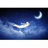 Young blond girl flying in night sky