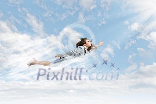 Young pretty businesswoman flying in blue sky