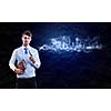 Young handsome businessman smoking pipe against black background