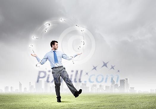 Handsome businessman juggling with question marks against city background Handsome businessman juggling with question marks against city background