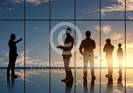 Silhouettes of businesspeople standing against panoramic office window Silhouettes of businesspeople standing against panoramic office window