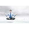 Young businessman sitting in lotus pose and meditating