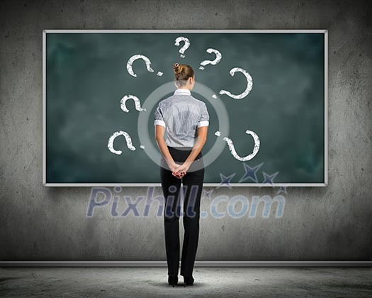 Rear view of businesswoman looking at chalkboard
