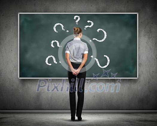 Rear view of businesswoman looking at chalkboard Rear view of businesswoman looking at chalkboard