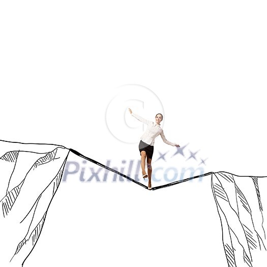 Young businesswoman walking on rope above mountain gap