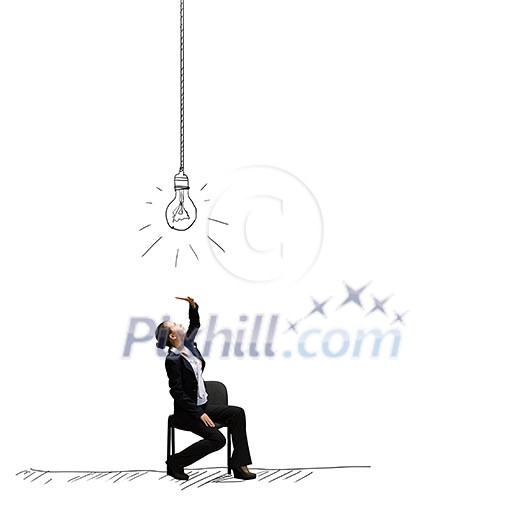 Young businesswoman sitting on chair under light