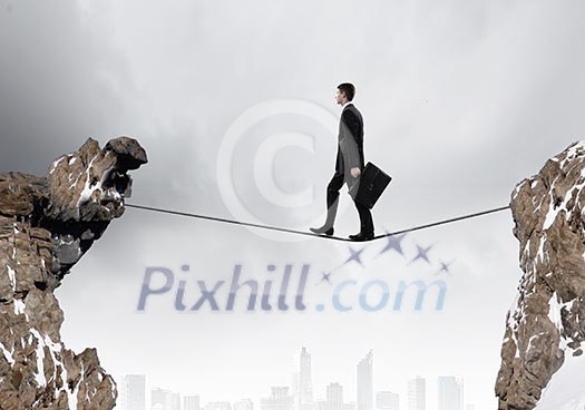 Conceptual image of businessman walking on rope above gap