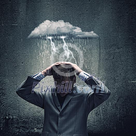 Businessman sitting under rain protecting head with arms Businessman sitting under rain protecting head with arms