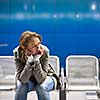 Sad and alone in a big city - Depressed young woman sitting in a metro station, feeling sorrow, regret