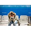 Sad and alone in a big city - Depressed young woman sitting in a metro station, feeling sorrow, regret