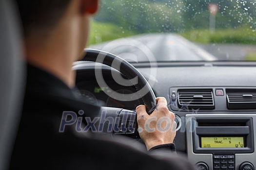 Man driving a car with his hands on the steering wheel