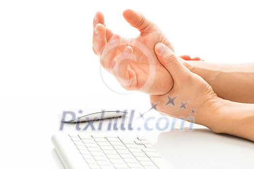 Working too much - suffering from a Carpal tunnel syndrome - young man holding his wrist in pain due to prolonged use of keyboard and mouse over white background (color toned image; shallow DOF)