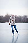 Young woman ice skating outdoors on a pond on a freezing winter day