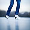 Young woman ice skating outdoors on a pond on a freezing winter day