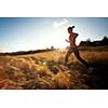 Young woman running outdoors on a lovely sunny winter/fall day (motion blurred image)