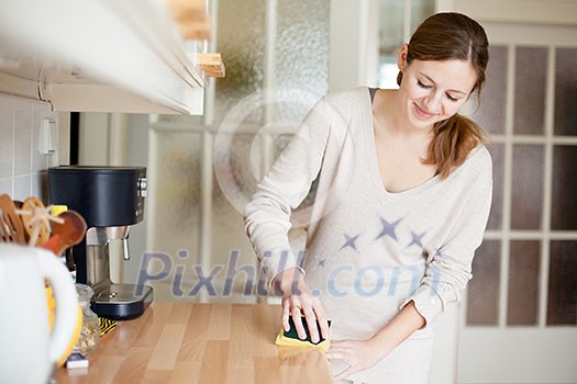 Young woman doing housework, cleaning the kitchen