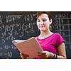 pretty young college student by the chalkboard/blackboard during a math class (color toned image)