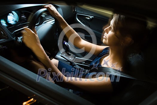 Driving a car at night - pretty, young woman driving her modern car at night, in a city (shallow DOF; color toned image) Driving a car at night - pretty, young woman driving her modern car at night, in a city (shallow DOF; color toned image)
