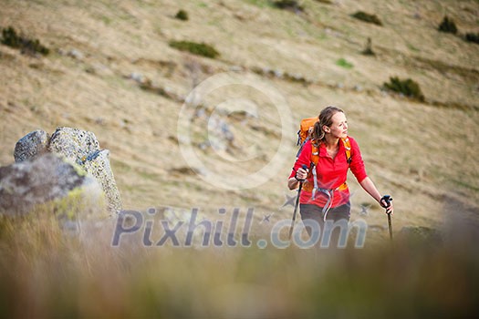 Pretty, young woman hiking in mountains