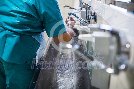 Surgeon in hospital washing thorouughly his hands before performing a surgery (color toned image; shallow DOF) Surgeon in hospital washing thorouughly his hands before performing a surgery (color toned image; shallow DOF)