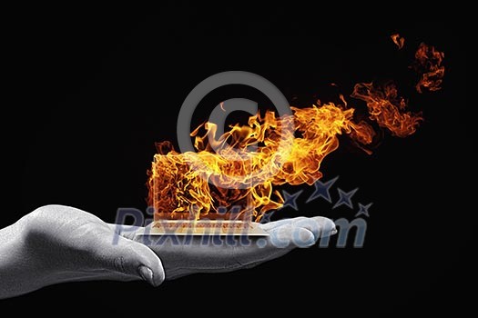 Human hand holding burning laptop on palm Human hand holding burning laptop on palm