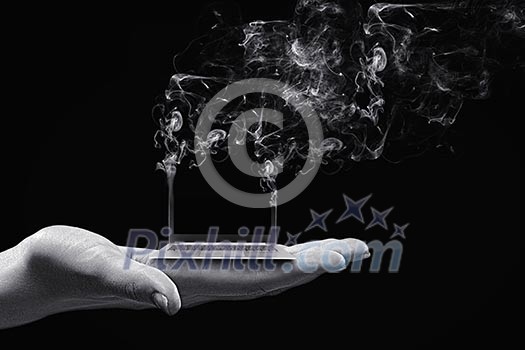 Human hand holding burning laptop on palm Human hand holding burning laptop on palm