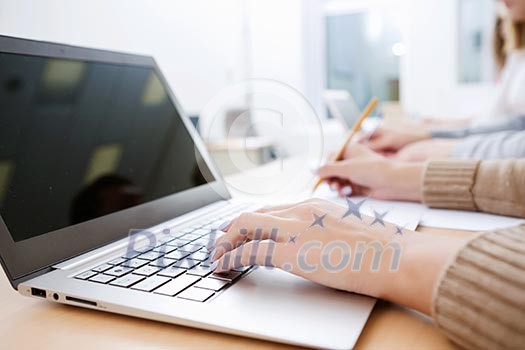 Close up image of young people using laptop at classroom