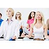 group of young people meditating on table in classroom