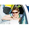 Young handsome man in sun glasses sitting in car