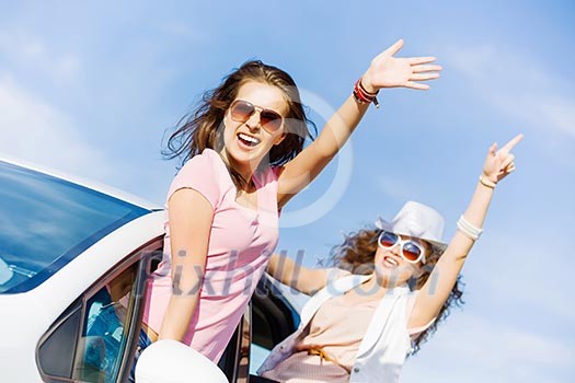 Young pretty women leaning out of car window