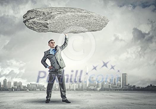 Powerful businessman holding huge stone above head Powerful businessman holding huge stone above head
