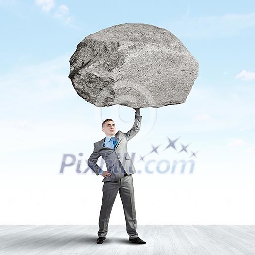Powerful businessman holding huge stone above head Powerful businessman holding huge stone above head