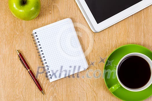 Tablet pc cup of coffee and notepad at table