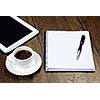 Tablet pc cup of coffee and notepad at table