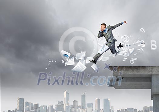 Young businessman jumping over bridge gap. Risking in business