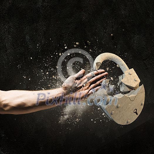 Image of human hand breaking stone lock Image of human hand breaking stone lock