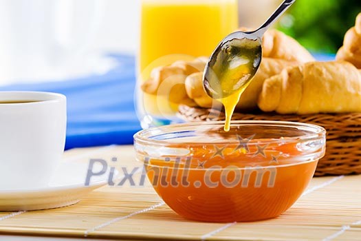 Croissants jelly and cup of coffee on breakfast table