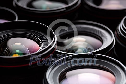 Modern camera lenses with reflections, low key image