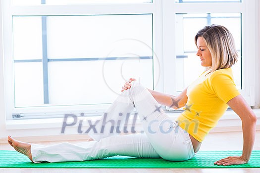 Pretty young woman doing YOGA exercise at home
