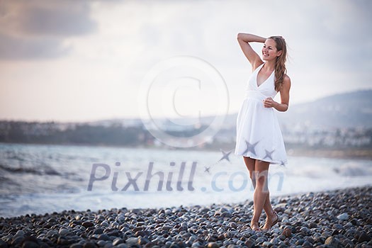 Young woman on the beach enjoying a warm summer evening Young woman on the beach enjoying a warm summer evening