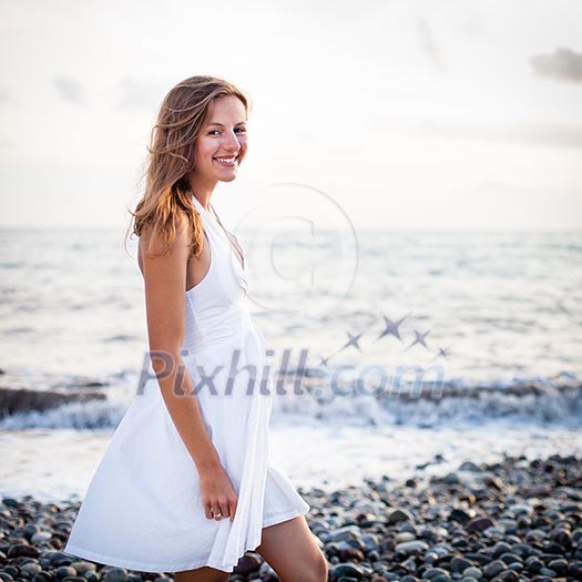 Young woman on the beach enjoying a warm summer evening Young woman on the beach enjoying a warm summer evening