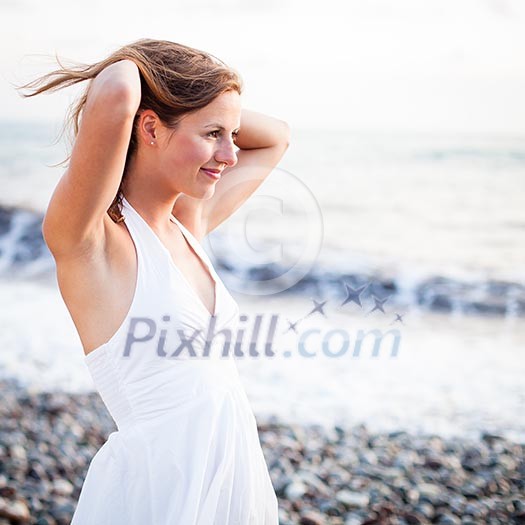 Young woman on the beach enjoying a warm summer evening Young woman on the beach enjoying a warm summer evening