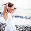 Young woman on the beach enjoying a warm summer evening