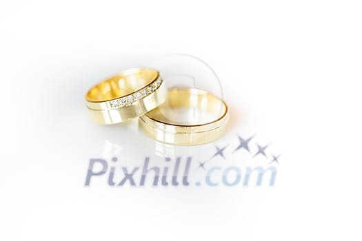 Wedding day details - two lovely golden wedding rings awaiting their moment, with some nice reflections Wedding day details - two lovely golden wedding rings awaiting their moment, with some nice reflections