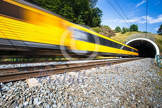 Fast train passing through a tunnel on a lovely summer day (motion blurred image) Fast train passing through a tunnel on a lovely summer day (motion blurred image)