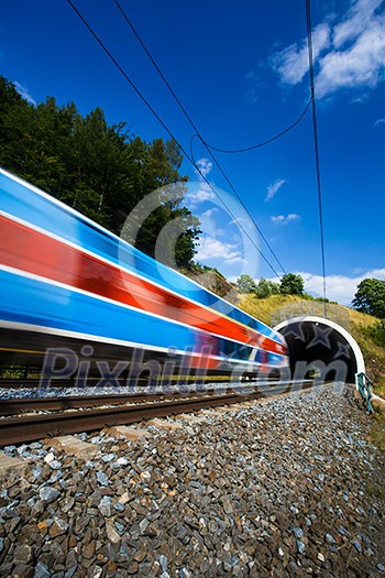 Fast train passing through a tunnel on a lovely summer day (motion blurred image) Fast train passing through a tunnel on a lovely summer day (motion blurred image)