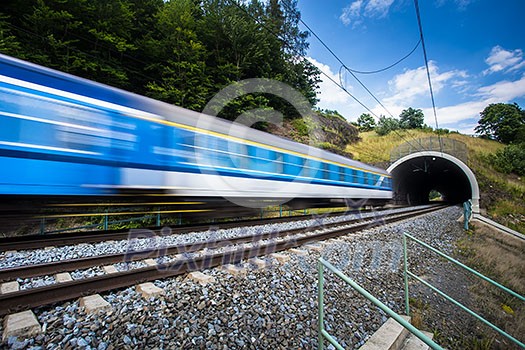 Fast train passing through a tunnel on a lovely summer day (motion blurred image)