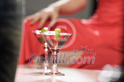 Close up of woman in red dress with cocktail in hands Close up of woman in red dress with cocktail in hands