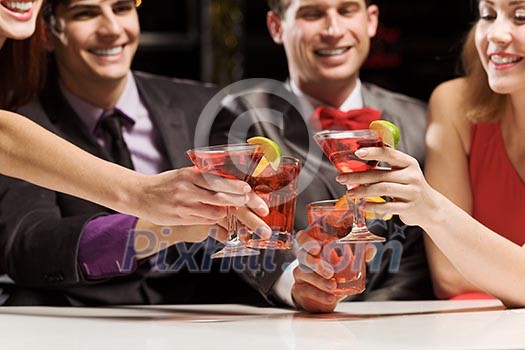 Young attractive people of four having cocktail party