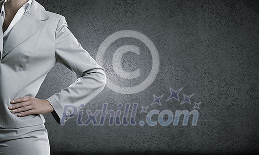 Chest view of businesswoman in suit against cement wall